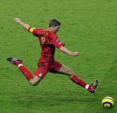 A man wearing a red football kit.