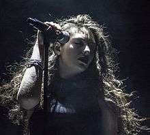 Lorde singing holding a microphone