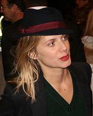 Laurent wearing a black hat and a black top looking away from the camera.