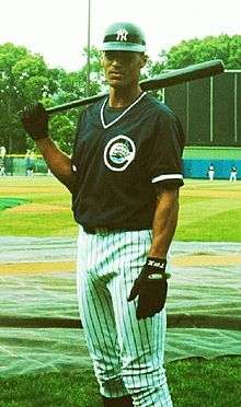 Marcus Jackson standing, with a baseball bat over his right shoulder.