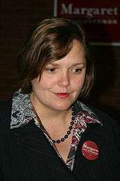 A woman wearing a suit with a Margaret Anderson Kelliher for Governor button.