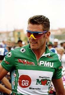 A cyclist wearing a green jersey.