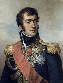 Painting of a man with dark hair, eyebrows and sideburns. He wears a dark blue military uniform with epaulettes, a high collar, many decorations and a red sash across his shoulder.