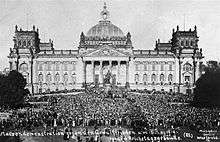 Thousands of people gather in front of a building.