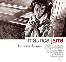 A woman grasping her hands together looks off to her left while standing against a wall. Text below the image reads "Maurice Jarre", followed by other French text.