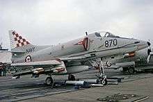 Colour photograph of a military jet aircraft parked at an airfield