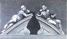 Two male figures reclining on the stone gate pillars of the Bethlem entrance, carved in Portland stone. Both figures are semi-naked. The figure on the left represents melancholic madness and looks languid and lethargic. The figure on the right, representing frenzied madness is restrained by chains and its body looks taut and muscular.