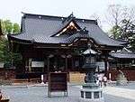 A wooden building with a hip and gable style roof.