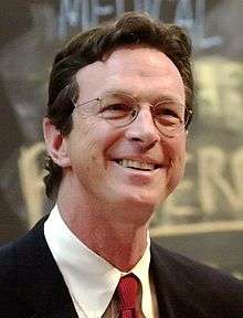 Michael Crichton wearing a suit.