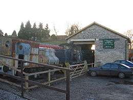 Stone building with steam railway engine outside it.