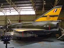 Single-engined, delta-wing military jet in a hangar