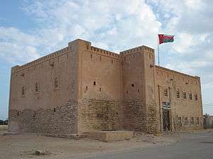 sand coloured square castle with flag flying