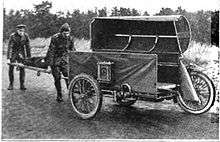 Stretcher being loaded into a motorcycle sidecar by two men