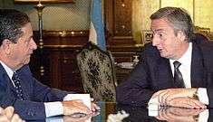 Kirchner talking to President Eduardo Duhalde at a table