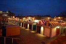 Parallel rows of market stalls with multi-coloured roofs