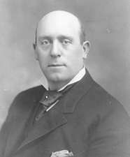 A black-and-white photo of a bald, middle-aged man