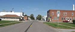 The downtown area of a small town bisected by a highway.