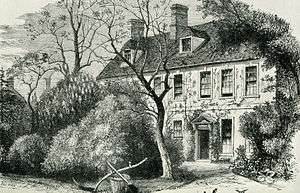 Engraving of a two-storey building, eight windows across, partially obscured by trees and shrubs