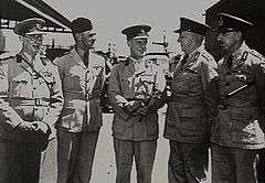 Five men in light-coloured military uniforms