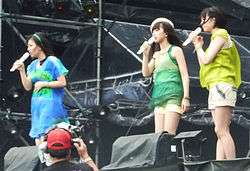 Three women on stage at a music concert