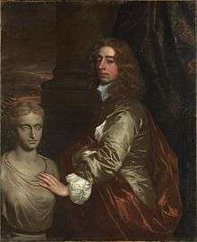 Nobleman dressed in silk posing by an antique bust