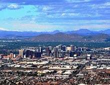 A photo showing the skyline of Phoenix, looking north.  It shows the various buildings of the downtown area, as well as Sunnyslope Mountain in the background