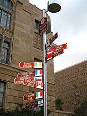 photo of signpost with ten signs pointing in the direction of Phoenix's sister cities, stating their names and distances from Phoenix.