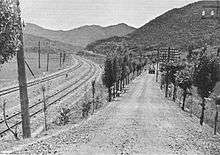 A road and railway running through mountains