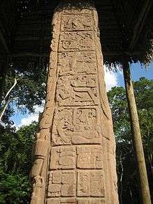 The side of a stela, divided into square panels containing sculpted heieroglyphs