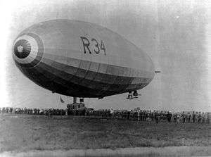 Airship landing, surrounded by a crowd of people