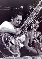 Black and white photograph of a man playing Sitar.