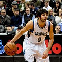 Ricky Rubio in a white Timberwolves uniform dribbling the basketball