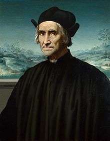 Portrait of Benivieni as an old man wearing a black cassock and hat seated in front of a snowy landscape painting.