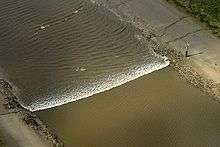 A tidal bore wave moves along the River Ribble between the entrances to the Rivers Douglas and Preston.