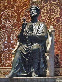  Peter is shown as a bearded man in draped garment like a toga. He is seated on a chair made of marble, and has his right hand raised in a gesture of blessing while in his left hand he holds two large keys. Behind the statue, the wall is patterned in mosaic to resemble red and gold brocade cloth.
