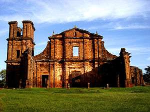 Ruins of a stone church facade and tower.