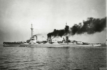 A large ship steams at full speed: the ship plows into the sea while dark gray smoke pours from its smoke stacks.