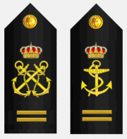 Two diagonal fouled anchors above two horizontal gold stripes, and a single fouled anchor above two gold stripes.