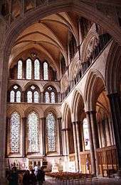 A view into the north transept at Salisbury shows a harmonious arrangement of lancet arches rising in three tiers of various sizing and grouping. The details are enhanced by narrow attached shafts of dark-coloured Purbeck marble. The ribbed vault is of a simple form.