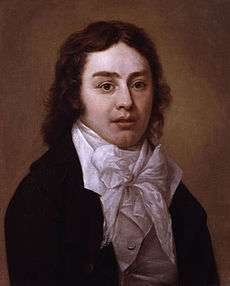 Half-length portrait of man wearing a black jacket and white shirt with an elaborate white bow at the neck. He has wavy, medium-length brown hair.