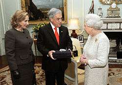 Color image of Chilean President Sebastián Piñera and First Lady Cecilia Morel presenting a souvenir gift rock from the San Jose Mine to Queen Elizabeth II on 18 October 2010 during a state visit to the UK