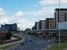 The start of the Sheffield Parkway, as viewed from Park Square, where it meets the City Centre. The road, in the centre, is six lanes wide and leads towards the Parkway Edge development (left-centre) where the road meets the Inner Ring Road. To the right is the Sheffield Supertram viaduct and beyond that a new apartment complex.