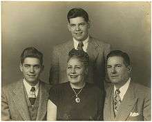 A portrait of a teenage Silvers standing behind seated family members