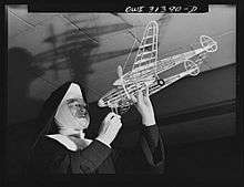 Washington, D.C. Sister Aquinas, "flying nun," applying a little glue to the model P-38 which hangs from the ceiling of her classroom at Catholic University. A veteran of fifteen years' teaching experience, the Sister is giving a summer Civil Aeronautics Authority course for instruction
