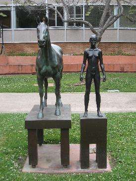 Nude female standing next to a horse