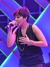 Chauhan singing a song, wearing a black top