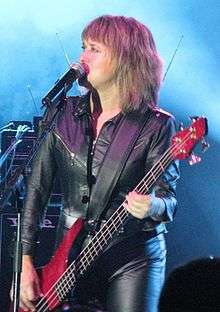 Quatro, playing bass guitar, performing in Australia.