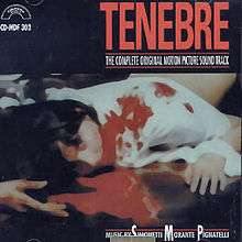 A figure with dark hair and wearing a white shirt prone in a pool of blood. Above, "TENEBRE".