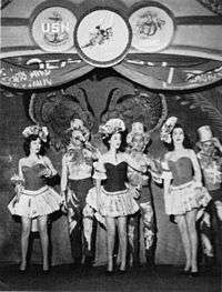 Three women and three men on stage in a chorus number