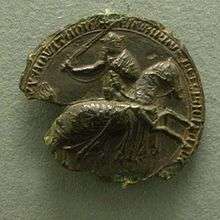 Partly ruined black seal, showing Edward III on horseback, in armour and sword raised.